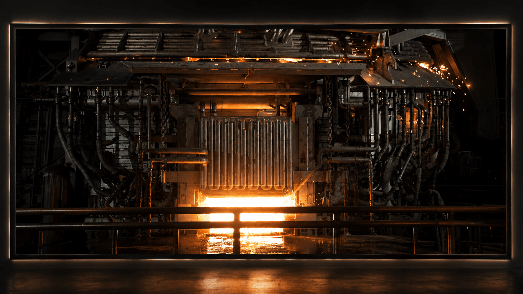 The same pulpit video wall pointed at another furnace — its mouth glowing on the panels.